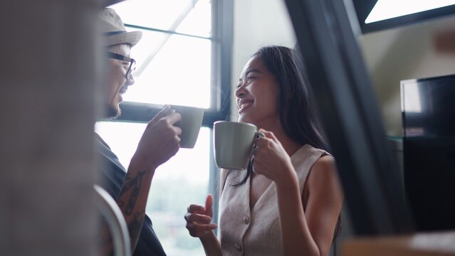 Happy young couple enjoying coffee together, sharing a laugh and conversation