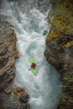 View of a kayaker in a green kayak navigating the white water rapids of the Rio Manso canyon San Carlos de Bariloche, Rio Negro, Argentina.