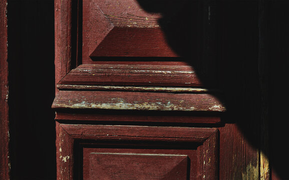 Red wooden door abstraction. Shabby rustic exterior, wood trim, painted wood, carpentry craft. Abstract lifestyle wallpaper, wood material