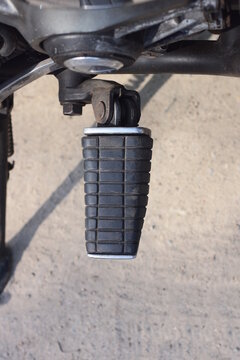 One black plastic metal footrest on a motorcycle on a summer street