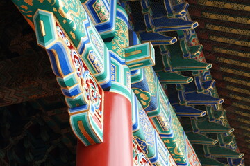Detailed Ornamentation of Traditional Chinese Palace Architecture with Golden Dragon Patterns and Vibrant Corbel Brackets © Denise