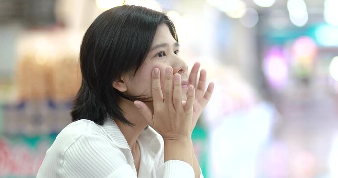 Young woman sadness and shock in a public place, representing stress, anxiety, emotional problems, mental health, and human feelings