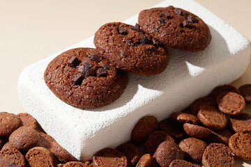 Fototapeta premium Chocolate Cookies on a White Pedestal with bite-size cookies around it