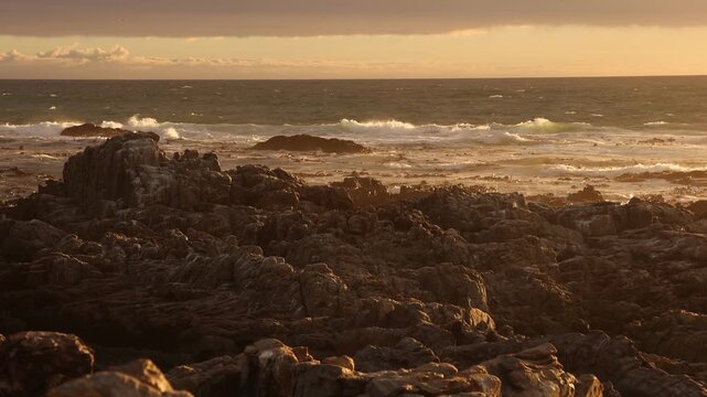 sunset light over rocky coastline of DeKelders, Gansbaai, South Africa