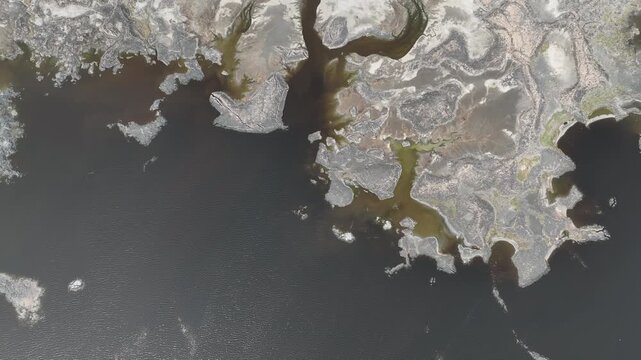 Aerial view of Danakil Desert showing salt crusts and dark mineral pools in the volcanic landscape of Dalol, Afar, Ethiopia.