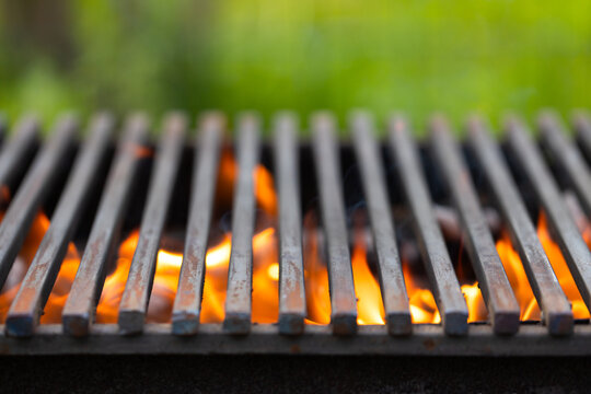 Barbecue grill with fire flames and blurred green background