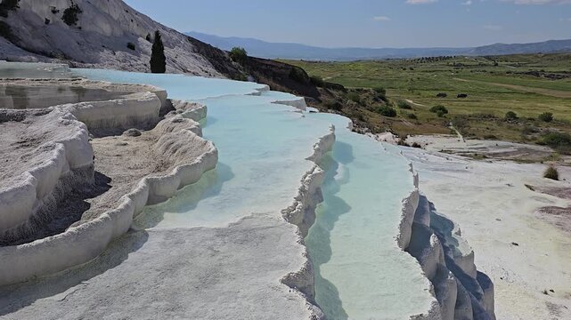 Explore the stunning white travertine terraces and thermal waters of Pamukkale in Turkey. Experience a unique landscape where nature creates serene pools and beautiful views.