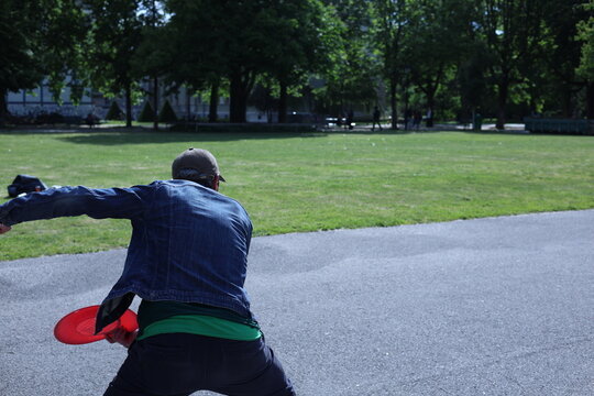 Homme jouant au frisbee dans un parc urbain