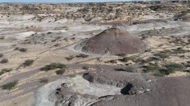 Aerial view of the Danakil Desert featuring unique geological mounds and sparse vegetation across the arid landscape in Dalol, Afar, Ethiopia.