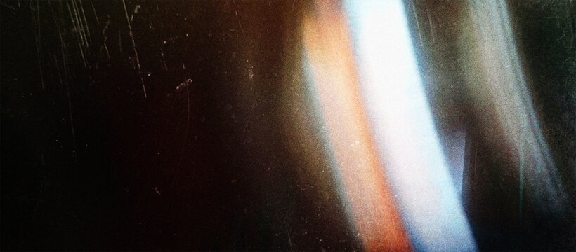 Vintage grunge warm light leak effect, abstract orange and blue blurred background showing lens flare, film grain, scratches and dust
