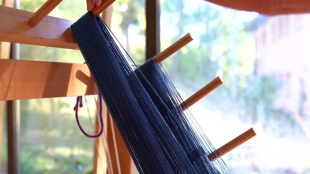 Close up of traditional weaving process on wooden loom
