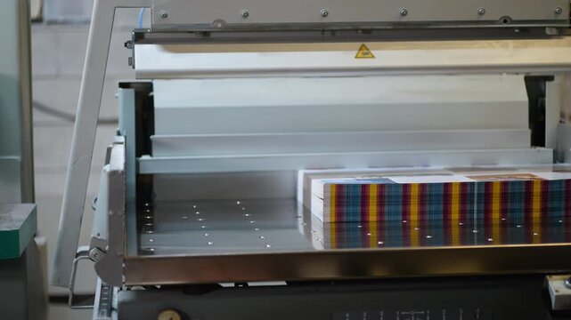 Industrial printing machine packaging stack of freshly printed sheets