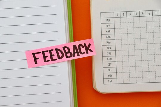 Post-it note with the word "Feedback" on a personal planner (in Portuguese). Scheduling a performance review, employee evaluation. 