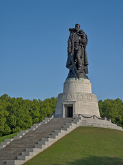 Fototapeta premium Sculpture of a soldier with a sword carrying a child, Soviet war memorial in Treptower park, Berlin, Germany 