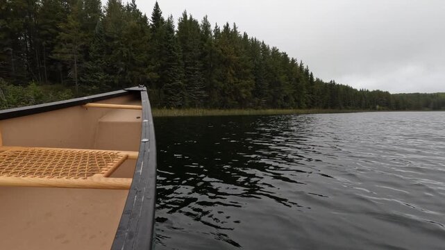 POV view from a canoe paddling on a northern park lake with the canoe shown along the left side of the frame
