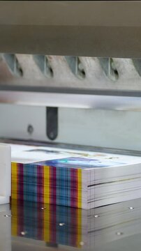 Printing machine producing colorful paper stacks in print plant