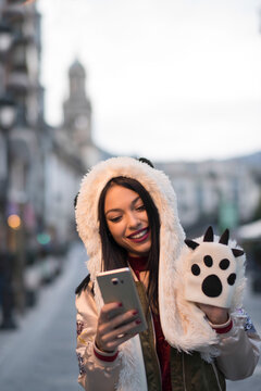 Women in the city with cute cat clothes making video call with smartphone
