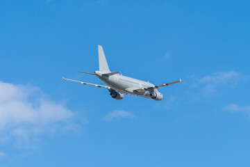 Fototapeta premium Gray hungarian military transport plane flying in the blue sky