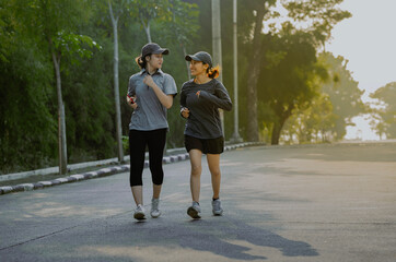 Fototapeta premium Beautiful sport asian woman and friend in sportswear jogging running in the park. Healthy lifestyle and sport concept.