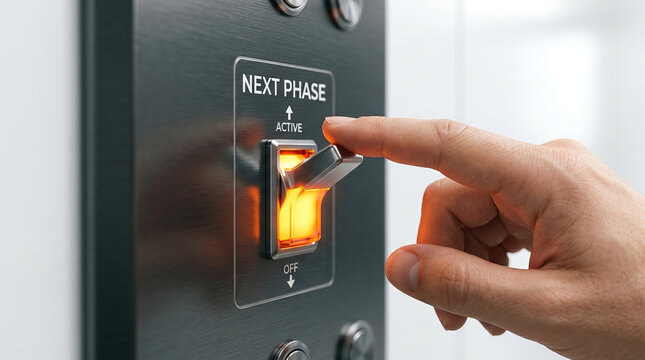 Hand toggling switch with illuminated orange light on metal control panel, close up of finger flipping lever to next phase active position, industrial equipment operation