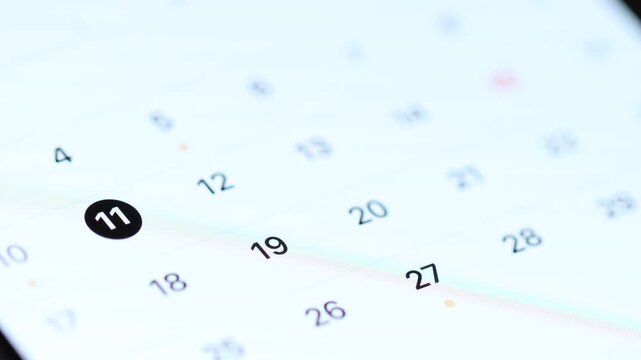4K macro view of a finger tapping several dates on a digital calendar app and scrolling up to see the next month.