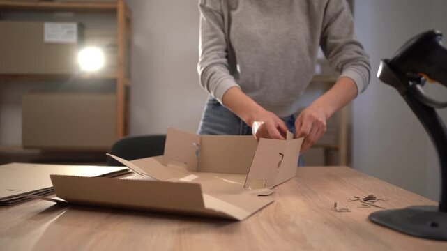 Woman packing boxes in home workspace, business logistics and packaging services. e-commerce and business concept.