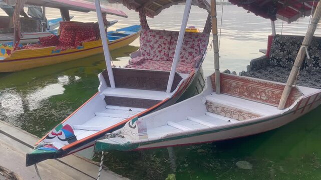 Traditional Wooden Boats Floating on Calm Water at Lakeside Dock shikara ride on dal lake