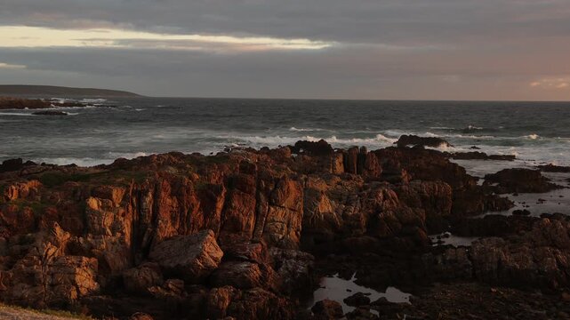 sunset light over rocky coastline of DeKelders, Gansbaai, South Africa