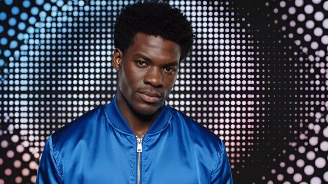 Young Black Man in Blue Bomber Jacket Posing Confidently Against a Dazzling Light Background.