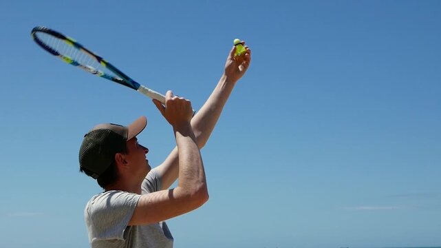 Man performing speed badminton serve on sandy beach , athletic training, shuttlecock practice, active lifestyle, summer outdoor fitness.