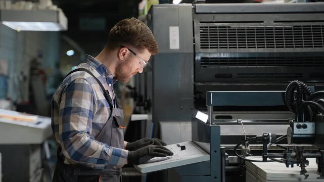Print technician operating industrial printing press machine