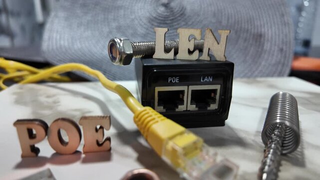 Wooden letters spelling POE and LEN are arranged with networking hardware and cables.