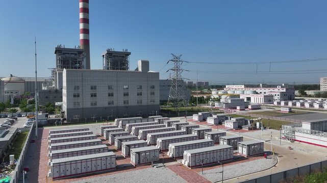 Thermal power plant with rows of energy storage container units under clear blue sky
