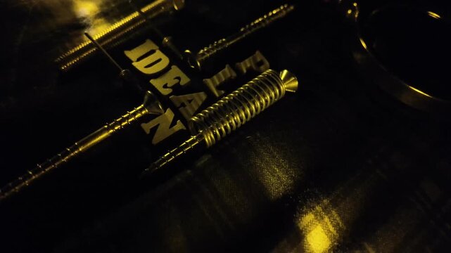 A bright yellow word 'DEAN' is illuminated against a dark background with reflections.