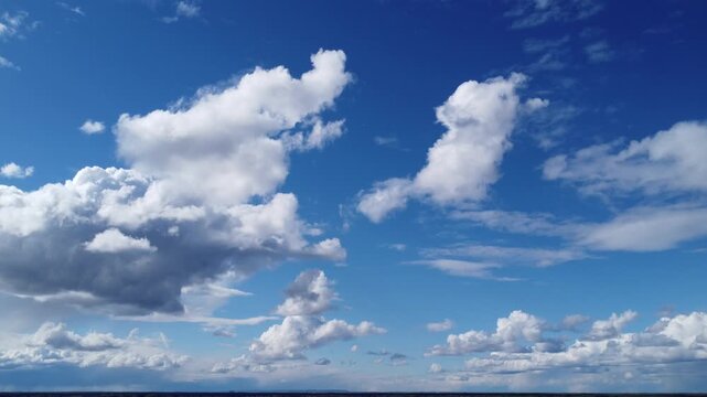 4K aerial drone view of white towering cumulus clouds in a deep blue sky, cinematic high altitude flight, beautiful cloudscape background for video projects, bright sunny day, atmospheric nature foota