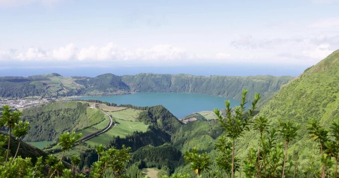 A beautiful view of a volcanic lake in a crater surrounded by mountains at Sete Cidades.