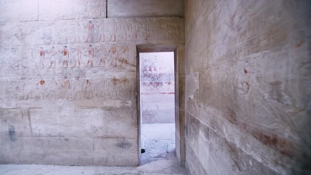 Close-up of detailed limestone relief carving inside tomb of Kagemni at Saqqara, Egypt, depicting ancient Egyptian male figures with tools, faint traces of original red pigment.
