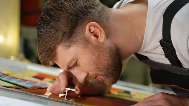 Print technician inspecting color quality with magnifying glass