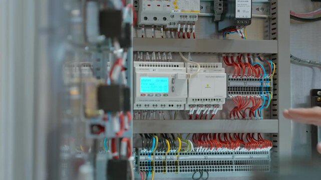 Rows of electrical devices in industrial equipment that ensure proper operation have shut down the line due to an accident, as shown on the screen and the person in charge draws attention to. Closeup