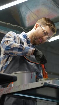 Professional polygrapher mixing yellow ink in printshop