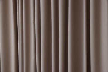 Fototapeta premium Stylish dark beige curtains as background, closeup