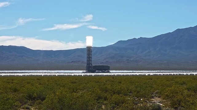 Solar Power Tower In Mojave Desert Landscape, cinematic renewable energy video frame with bright heliostat field and mountain backdrop