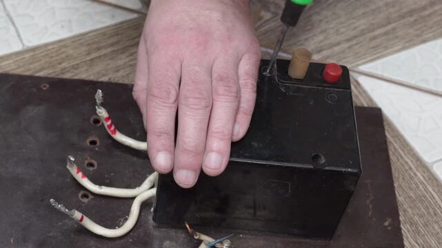 An electrician disassembles and repairs an old circuit breaker, The process of maintenance, diagnostics or restoration of old industrial electrical equipment.