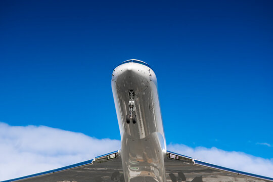 avi&oacute;n de pasajeros privado aterrizando. fondo nublado y con nubes y cielo azul