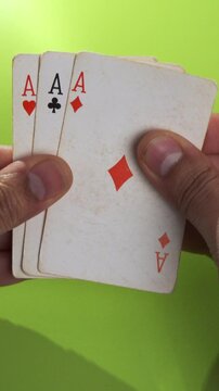 Hand holding playing cards and looking at them