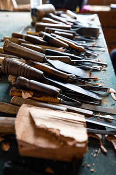 Professional wood carving tools gouges and wooden mallet on an artisan workbench