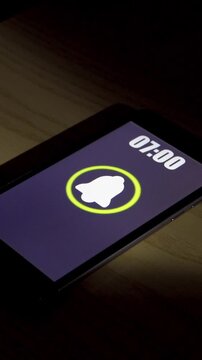 Smartphone alarm clock app rings for wake up, screen shows at bedroom