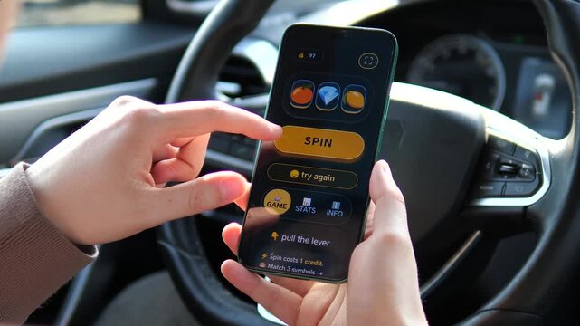 Close-up of a person playing a mobile slot machine game inside a car. Tapping the Spin button for digital gambling. Perfect for content about online casinos, addiction risks, and digital betting