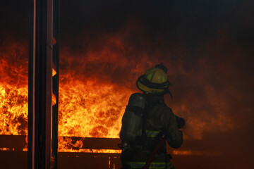 Naklejka premium Firefighter try extinguish the blaze fire flame