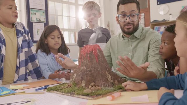 Teacher explaining volcano eruption to elementary class